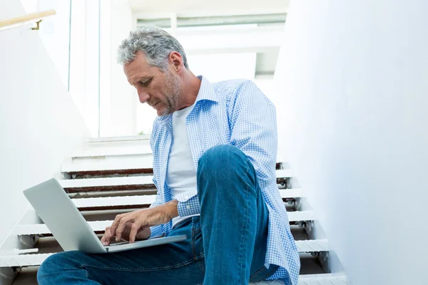 Homem usando laptop em passos — Fotografia de Stock