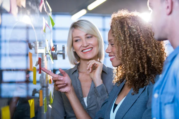 Mujer de negocios señalando en nota adhesiva — Foto de Stock