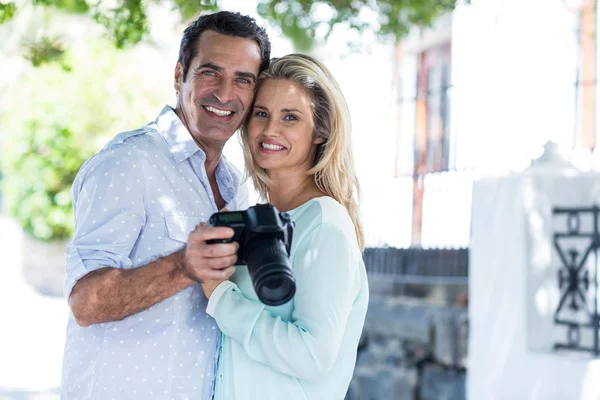 Happy couple with camera standing — Stock Photo, Image