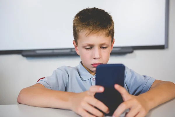 Schoolboy usando telefone celular em sala de aula — Fotografia de Stock