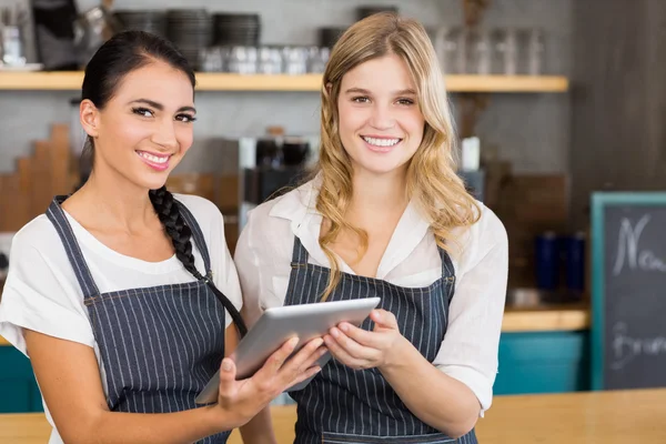 Portret van twee lachende serveersters met behulp van digitale tablet — Stockfoto