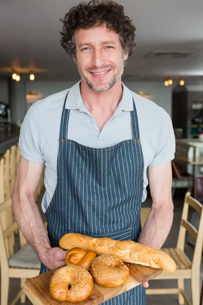 Camarero sosteniendo bandeja de madera con pan — Foto de Stock
