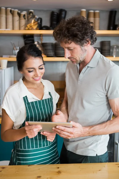 Cameriere e cameriera discutono su tablet digitale — Foto Stock