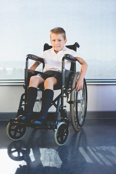 Portrait of schoolkid sitting on wheelchair — Stock Photo, Image