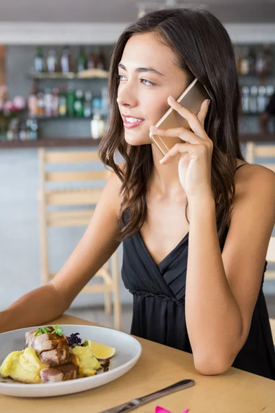 Mulher falando no celular enquanto tem refeição — Fotografia de Stock
