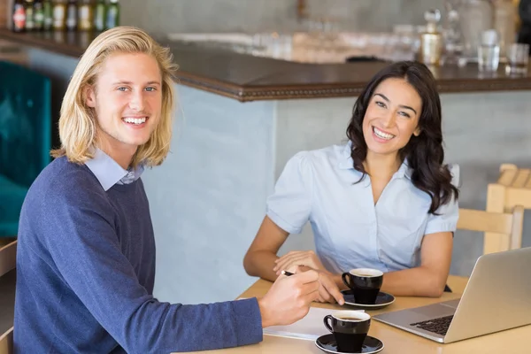 Business colleagues smiling while having a cup of tea — Stock Photo, Image