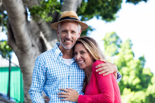 Pareja de pie contra el árbol — Foto de Stock