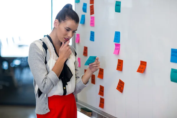 Frau liest Notizen im Büro — Stockfoto