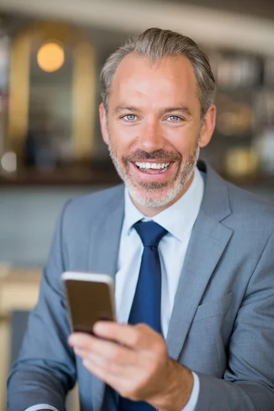 Empresário sorridente usando telefone celular — Fotografia de Stock