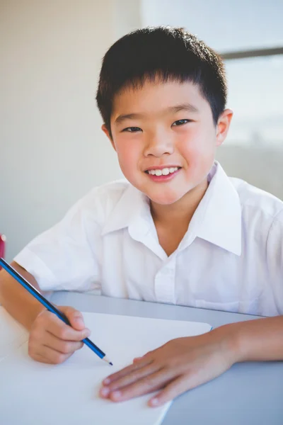 Skolpojke göra läxor i klassrummet — Stockfoto