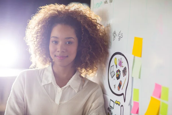 Woman standing by whiteboard in office — Stock Photo, Image