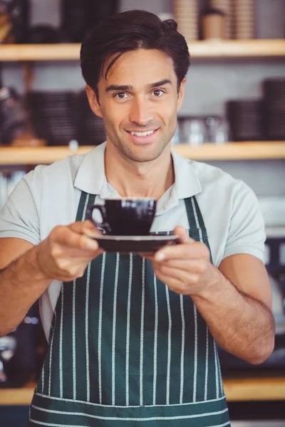 Официант предлагает чашку кофе — стоковое фото