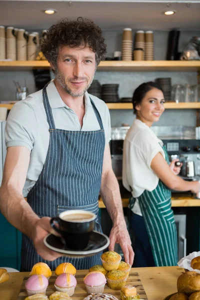 Официант держит чашку кофе — стоковое фото