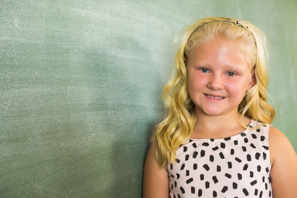 Portrait of smiling schoolgirl standing in classroom — Stock Photo, Image