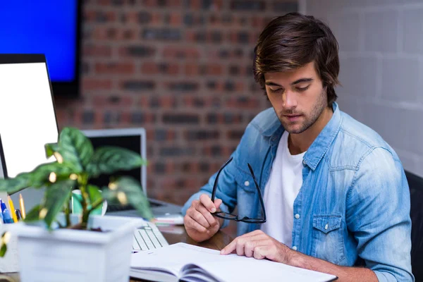 Hombre de negocios leyendo libro en el escritorio — Foto de Stock