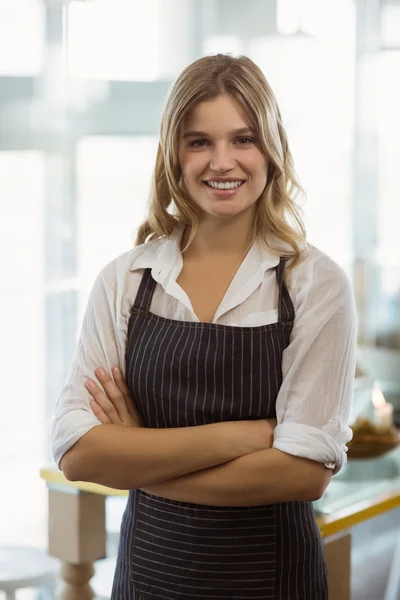 Portrét usměvavá servírka stojící s rukama přes — Stock fotografie