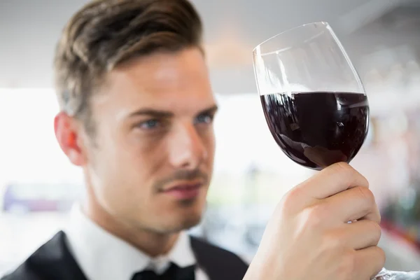 Waiter looking at a glass of wine — Stock Photo, Image