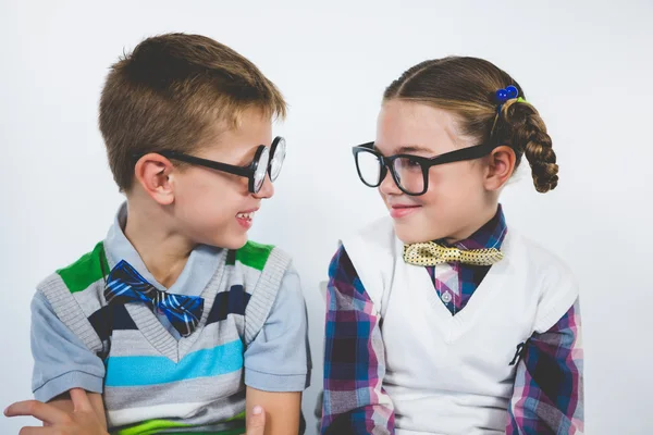 Lächelnde Schulkinder sitzen mit verschränkten Armen im Klassenzimmer — Stockfoto