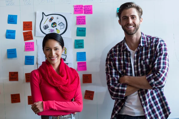 Colleagues standing against sticky notes — Stock Photo, Image