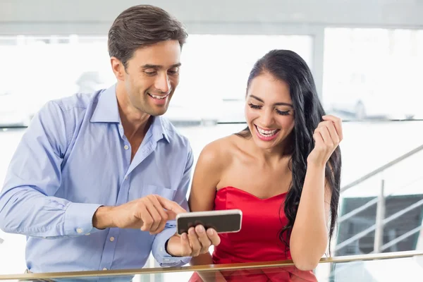 Pareja feliz usando el teléfono móvil en la cafetería —  Fotos de Stock