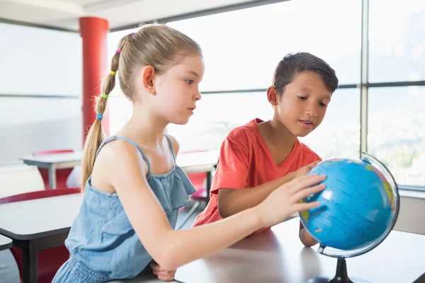 Schüler betrachten Globus im Klassenzimmer — Stockfoto