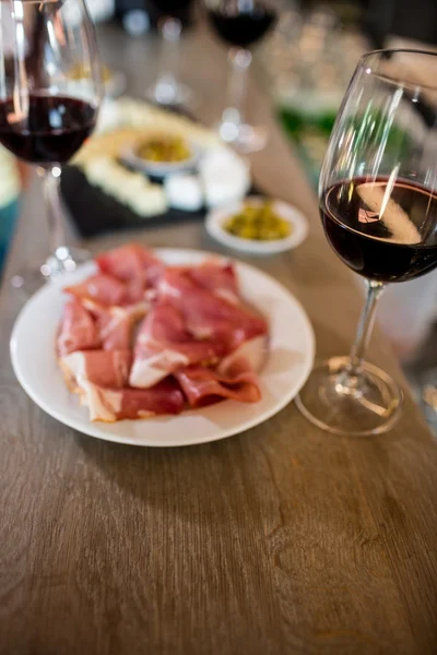 Carne y gafas de vino en la mesa en el bar — Foto de Stock