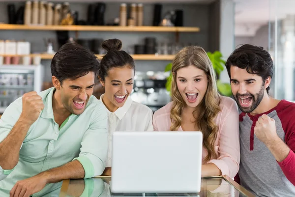 Grupo de amigos emocionados usando el ordenador portátil — Foto de Stock