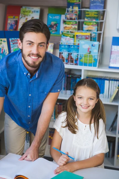 Enseignant et écolier souriant à la bibliothèque — Photo