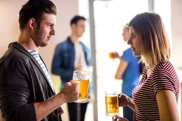Jeune couple avec des tasses à bière dans le bar — Photo