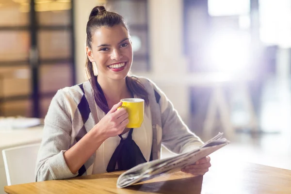 Woman holding newspaper in office — Stock Photo, Image