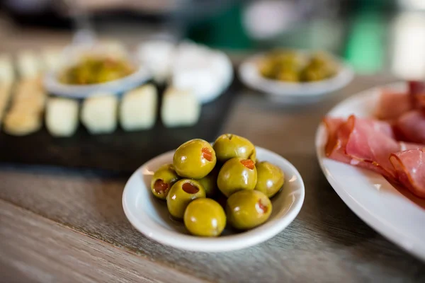 Πράσινες ελιές σε μπολ στο τραπέζι — Φωτογραφία Αρχείου