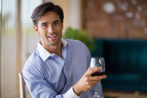 Porträt eines lächelnden Mannes mit einem Glas Rotwein — Stockfoto