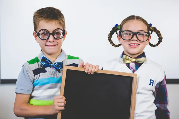 Retrato de crianças da escola sorrindo segurando ardósia em sala de aula — Fotografia de Stock