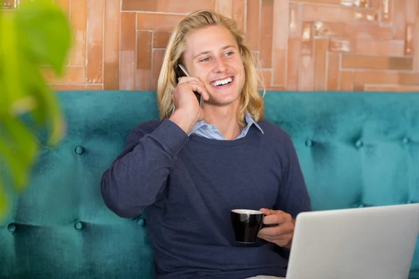 Man met kopje koffie tijdens het gesprek op de telefoon — Stockfoto