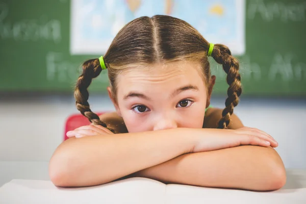 Retrato de colegiala apoyada en un libro en el aula —  Fotos de Stock