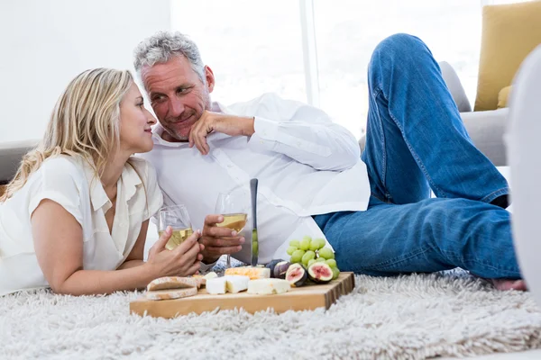 Pareja con vino blanco acostado — Foto de Stock