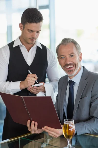 Kellner, der einem Geschäftsmann die Bestellung abnimmt — Stockfoto