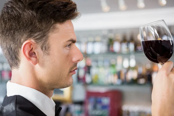 Cameriere guardando un bicchiere di vino — Foto Stock