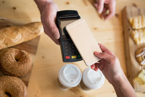 Woman making payment through NFC — Stock Photo, Image