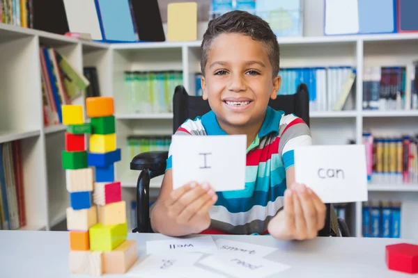 Ragazzo disabile che mostra cartello che recita I Can in biblioteca — Foto Stock