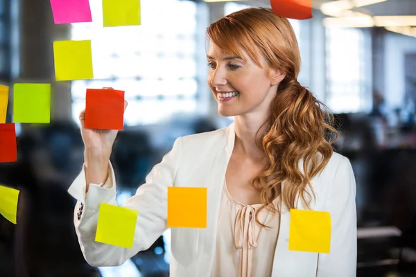 Empresaria escribiendo en notas adhesivas — Foto de Stock