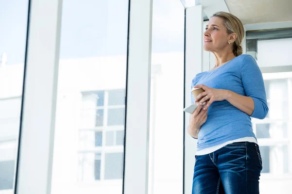 Thoughtful woman holding mobile phone — Stock Photo, Image