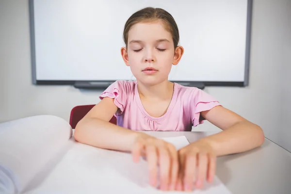Školačka čtení braille knihy v učebně — Stock fotografie