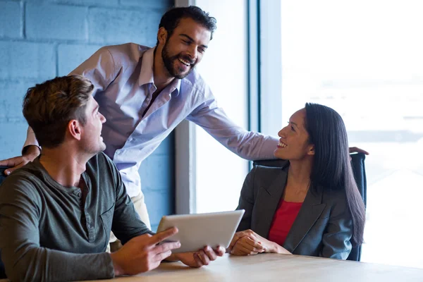 Happy colleagues using digital tablet in office — Stock Photo, Image