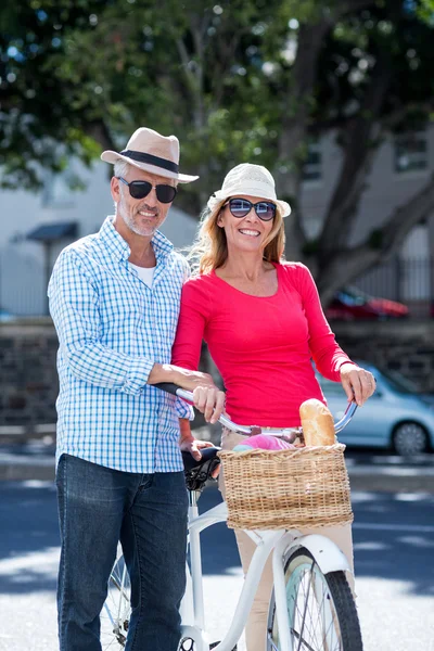 Mature couple with bicycle in city — Stock Photo, Image