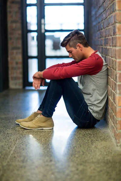 Stressad man sitter i byggnad — Stockfoto