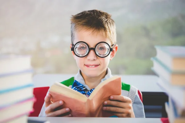 Portrait d'un écolier lisant un livre en classe — Photo