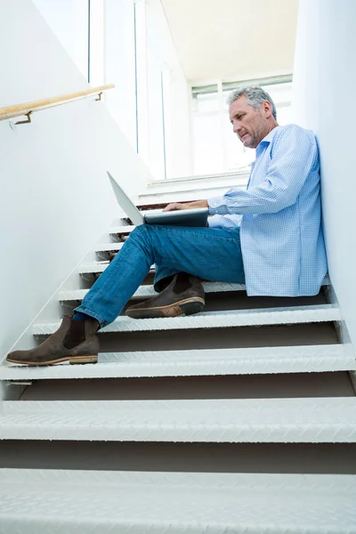 Man using laptop on steps — Stock Photo, Image