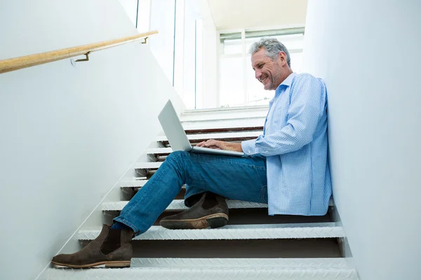 Man using laptop on steps — Stock Photo, Image