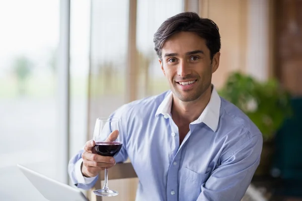 赤ワインのグラスを持って笑みを浮かべて男の肖像 — ストック写真